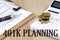 401K PLANNING word written on wooden block on planner with coins, clipboard and a calculator