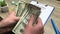 401k retirement plan, a man counts 100 dollar bills at a wooden table