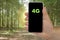 4G word written in a smartphone against a forest