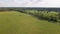 4K Aerial Drone Flyover of Fallow Field toward Manicured Golf Course