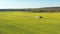 4K Aerial Elevated View Of Combine Harvester And Tractor Working Together In Field. Harvesting Of Oilseed In Spring