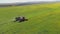 4K Aerial Elevated View Of Combine Harvester And Truck Working Together In Field. Harvesting Of Oilseed In Spring Season