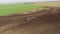 4K Aerial Elevated View.Tractor Plowing Field. Beginning Of Agricultural Spring Season. Cultivator Pulled By A Tractor