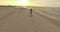 4k aerial - Gorgeous Girl Turns Around on a Sandy Beach at sunset