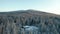 4k Aerial Shot Flying Away from Cabin on Hill in the Snowy Forest on a Clear Day