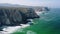 4K Aerial still view of Praia Grande beach, Portugal. Atlantic ocean waves and rocky cost cliffs in front