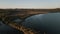 4k aerial view of La petite Camargue grass fields by the river in Saint-Chamas under blue sky