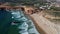 4K aerial view ocean waves rocky, cliffs sandy coast, beach Sagres Point Algarve Portugal 26 april 2023