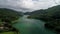 4K Aerial view over Paltinu lake and dam in Doftana Valley from Romania during a summer cloudy day - amazing water color