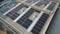 4K Aerial view of solar panels and air turbine mounted on warehouse roof