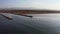 4k Aerial view of white lighthouse with breakwater. Mediterranean.