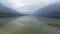 4K. Amazing Bohinj Lake in foggy weather and bird on the stone, panoramic view. Julian Alps, Triglav National Park, Slovenia.