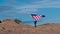 4k. Back view girl walking and waving national USA flag outdoors over blue sky at summer - american flag, country