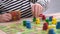 4k Board game and kids leisure concept - child hands close up playing wood chips people figure in children table top