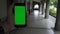 4K caucasian man show the Green Screen phone in aisle with columns