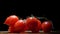 4k. Cherry tomatoes close-up. Rotating red Cherry tomatoes jn black background with water drops. Red Cherry Tomato Clockwise.