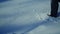 4K Close-up of feet walking on the snow desert. Shot from aside