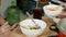 4k, A close-up hand is using a spoon to scoop the dipping sauce into the sukiyaki cup to prepare a delicious meal