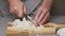 4K Close-up of male hands dicing onions on wooden board. Slicing of vegetables.