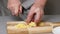 4K Close-up of male hands dicing potatoes on wooden board. Slicing of vegetables