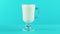 4K close-up shot of milk cold beverage drink pooring into latte glass mug blue background in studio