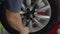 4K Close up shot tyre fitter is screwing a wheel with a special wrench