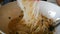 4K Close up shot woman hands using chopsticks picking and mixing white noodles in the bowl