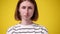 4k close-up video of upset offended woman isolated over yellow background.