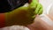 4k closeup spa and beauty concept. Master pedicure in green gloves applying nail polish. Professional pedicure procedure