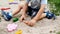 4k closeup video of adorable toddler boy digging sand with scoop in sandbox at park