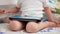 4k closeup video of little toddler boy sitting on bed and pressing digital tablet touchscreen with finger