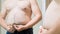 4k closeup video of obese man measuring big stomach at mirror