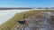 4K. Combine Harvester is working in the corn field after the First Snow! Harvester is cutting ripe dry corn. Aerial panoramic view