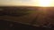 4k drone footage farmer driving tractor deep plowing land at sunset