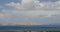 4k far away desert sand dunes,white puffy cloud mass rolling over blue lake.