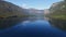 4K. Flight above amazing Bohinj Lake in the morning. People are training in rowing. Blue deep water and Julian Alps mountains.