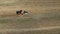 4K. Flight over harvesting potatoes with potato-digger trailer, tractor and people. Aerial top view