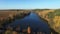 4K. Flight over lake and forest in golden autumn, aerial view.