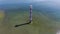 4K. Flight over old lighthouse standing in the sea, aerial view. Estonia, Saaremaa island