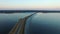 4K. Flight over road in the frozen lake in winter on sunset, aerial view