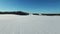4K. Flight and takeoff above snow fields in winter, aerial panoramic view. Winter land in the north