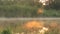 4k Fog hanging over water surface of the lake with sunlight shines through the forest background