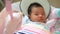 4K footage, adorable Asian baby feel sleepy , lying in a swing cradle