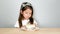 4K footage, adorable little girl hide to eating cake with her fingers and smile with shy face. hild model mixed race Asian-Europe