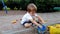 4k footage of adorable toddler boy playing with toys sitting in sandpit at playground