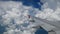 4K footage airplane flight. wing of an airplane flying above the white clouds and blue sky. beautiful aerial view from the window