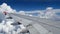 4K footage airplane flight. wing of an airplane flying above the white clouds and blue sky. beautiful aerial view from the window