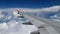 4K footage airplane flight. wing of an airplane flying above the white clouds and blue sky. beautiful aerial view from the window