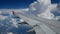 4K footage airplane landing flight. wing of an airplane flying above the white clouds and blue sky. beautiful aerial view