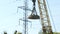 4k footage of big electric magnet hanging on high crane used for carrying and moving heavy metal pieces. Concept of